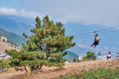 YALTA - 20 Eylül 2020: Kırım 'ın güneyindeki dağ manzarası yüksek dağlık plato boyunca yürüyen Ai Petri Güzel, uzun beyaz saçlı, kablo üzerinde tramvaya inen cesur kız