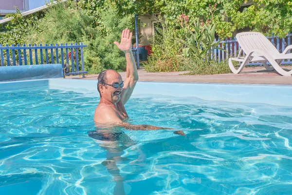 Un hombre nada en una piscina en el patio — Foto de Stock