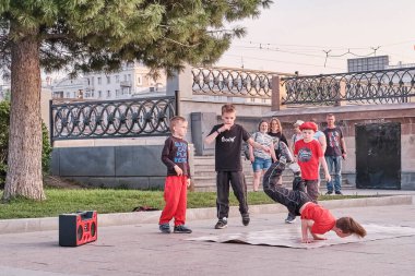 Erkekler şehir caddesinde breakdance yapıyor. Yalnız çocuk kollarında..
