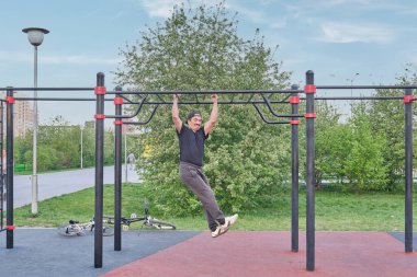 Kıdemli Asyalı adam şehir parkında spor alanında antrenman yapıyor. .