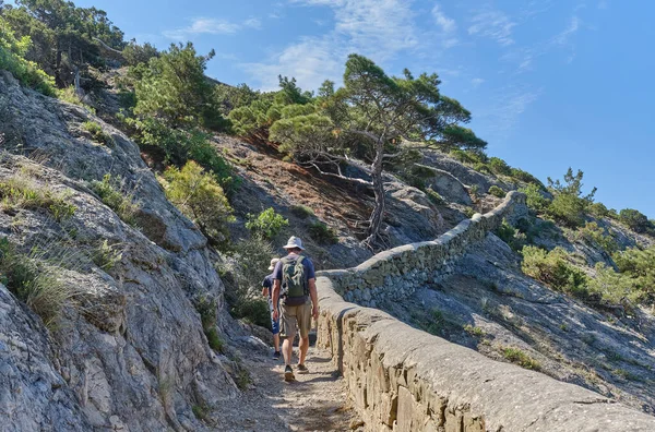 Un niño y su abuelo caminando por el pintoresco sendero Golitsyn. Reserva botánica nacional Nuevo Mundo, Crimea. — Foto de Stock