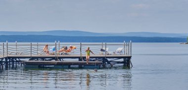 Kırsal yaz tatili. Aile Tavatui Gölü 'nde güneşleniyor ve yüzüyor..