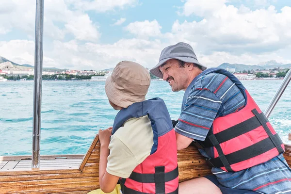 Азиатский мальчик в Панаме, спасательный жилет и его дедушка путешествуют на лодке удовольствия на море. — стоковое фото
