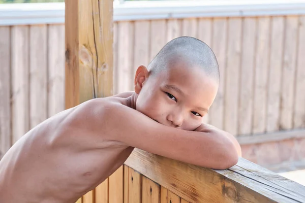Portret opalonego azjatyckiego chłopca z nagim tułowiem, łysa fryzura, patrząc w kamerę — Zdjęcie stockowe