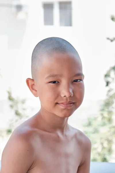 Portrait of a tanned Asian boy with a bald haircut. — Zdjęcie stockowe