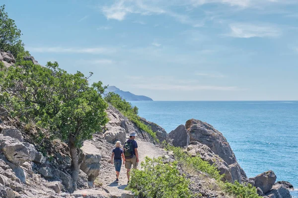 Boy and man hiking on the scenic Golitsyn trail. National botanical reserve New World, Crimea. View from back — Stock Photo, Image