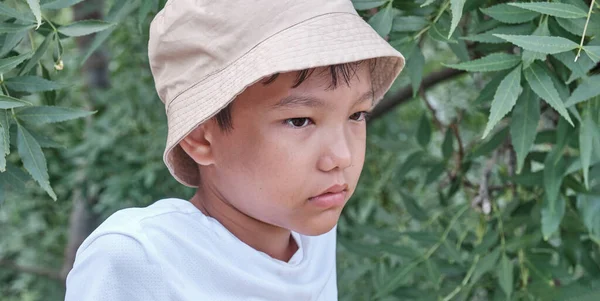 Asian boy in panama over background of green plants. — Zdjęcie stockowe