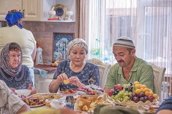 Local residents of Siberian village celebrate Muslim holiday Kurban Bayram at their home table. Villagers talking and eating. Eid al-Adha — Stock Photo, Image