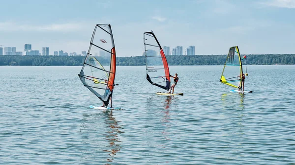 Windsurfing training. Several children floating on boards with sail on lake — Stock Photo, Image