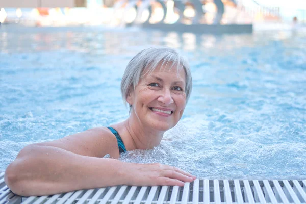 Seniorin mit grauen Haaren im Thermalfreibad mit Hydromassage. Stockbild