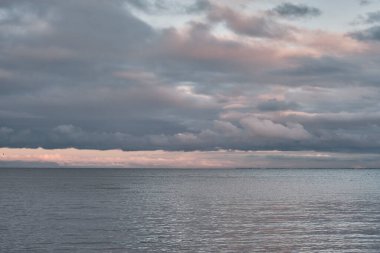Gün batımında deniz koyunda güzel, dramatik bulutlu gökyüzü