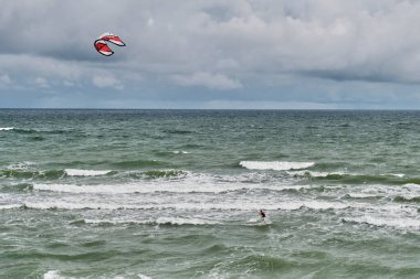 Uçurtma sörfçüsüyle güzel bir deniz manzarası.