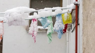 Kar yağışı sırasında dışarıda kuruyan kar örtülü havluların görüntüsü