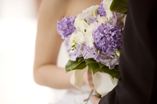 Married couple carrying bride's bouquet — Stock Photo, Image