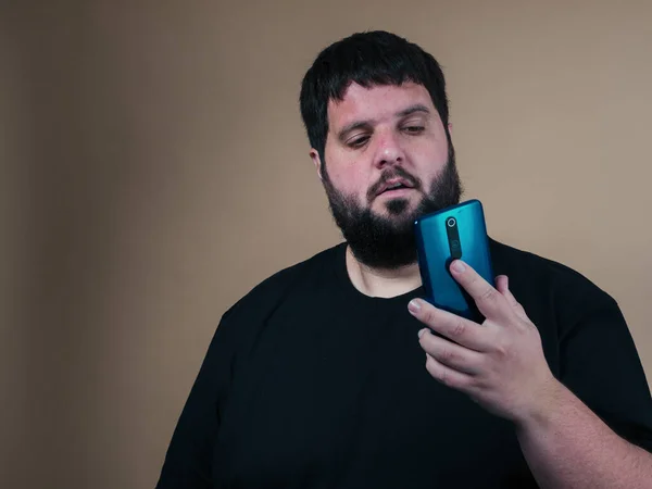 obese man with phone in hand