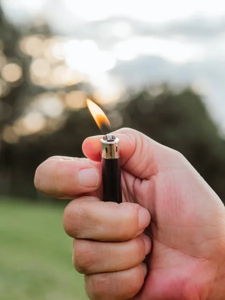 hand holding a lighter with flame