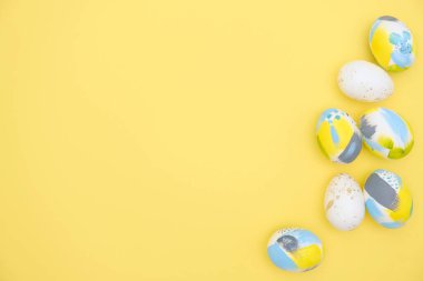 Düz paskalya kompozisyonu bir grup yumurtanın modaya uygun renklerde olduğu tebrik kartı metni ve afiş için kopyala-yapıştır ile yatıyordu