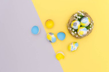 Paskalya 'nın düz kompozisyonu renkli yumurtaları son moda gri, sarı arka plana boyamış. Boş tebrik kartı maketi