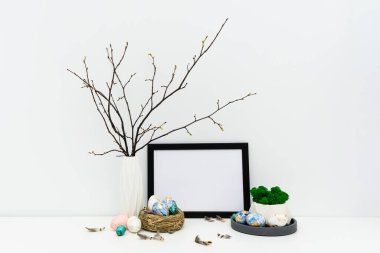Paskalya tasarımı için fotoğraf çerçevesi modeli. Paskalya kompozisyonu ön planda, arka planda elle boyanmış yumurtalar var.