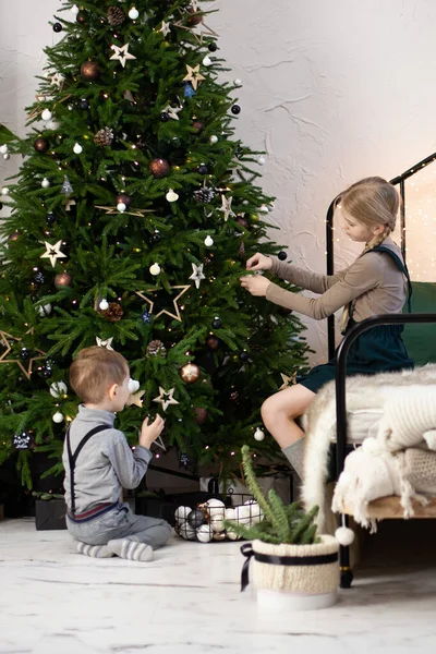 子供たちはクリスマスツリーを飾る メリークリスマスとハッピーニューイヤーのコンセプト — ストック写真