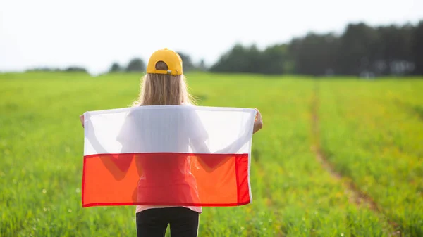 Yeşil Bir Tarlada Polonya Bayrağı Taşıyan Sarışın Kız Arkadan Bak — Stok fotoğraf