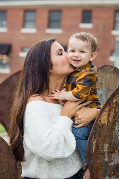Прекрасная мама с длинными каштановыми волосами держит своего малыша — стоковое фото