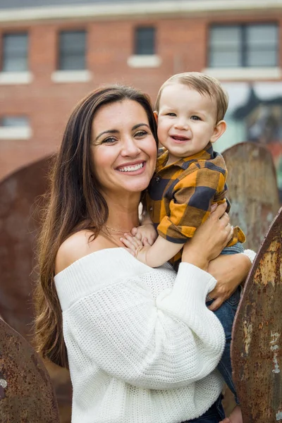 Прекрасная мама с длинными каштановыми волосами держит своего малыша — стоковое фото