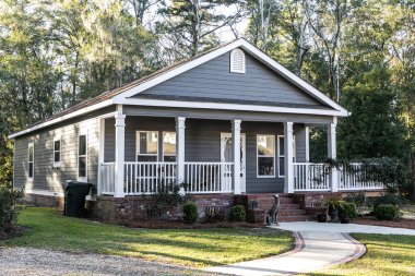 Ön ve yan verandası beyaz parmaklıklı küçük mavi gri mobil evi kapatın.