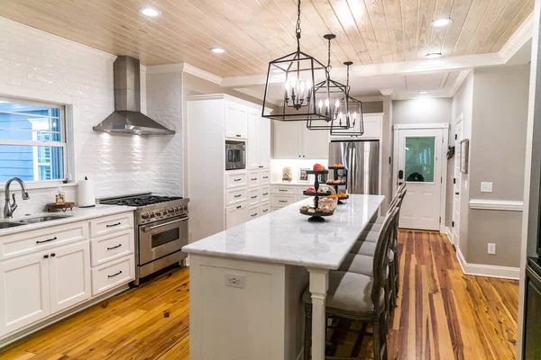 Amplia cocina blanca renovada con azulejos de metro texturizados, luces de hierro negro y pisos de madera de pino —  Fotos de Stock