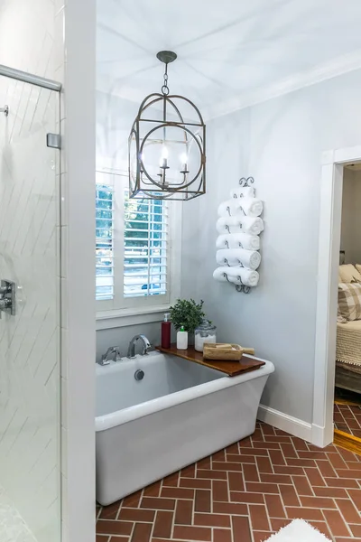 Large white renovated master bathroom bathtub with red brick floors — Stock Photo, Image