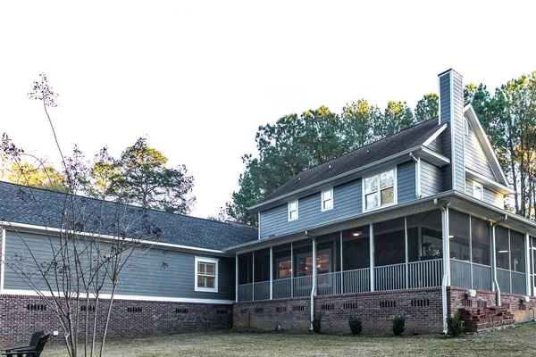 Zadní pohled na velký dvoupatrový modrý šedý dům se dřevěnou a vinylovou vlečkou — Stock fotografie