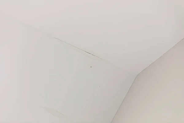 Una piccola perdita d'acqua dal tetto su un soffitto bianco interno — Foto Stock