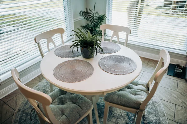 Primer plano de una pequeña mesa y cuatro sillas en un comer en la cocina con un piso de baldosas — Foto de Stock
