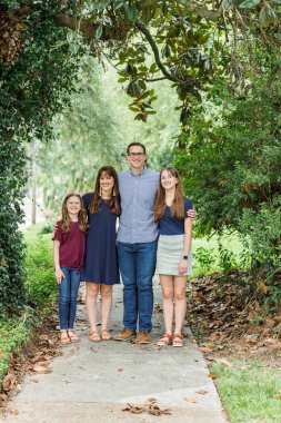 Anne, baba ve iki kızından oluşan bir aile yazın ya da sonbaharda kaldırımda dikiliyor.