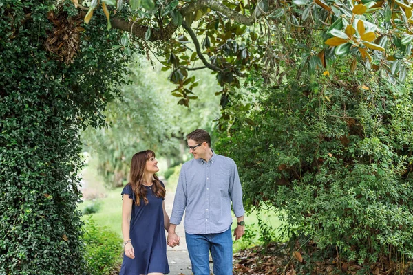 Una pareja de unos cuarenta años que son padres están dando un paseo por el vecindario en la acera afuera en el verano. —  Fotos de Stock