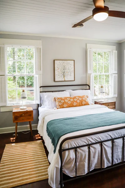 Un dormitorio de invitados con una cama tamaño queen y mesita de noche en una pequeña casa de estilo cabaña de alquiler a corto plazo —  Fotos de Stock