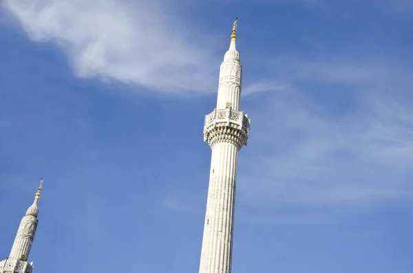 two isolated minarets on blue sky with some light clouds