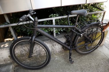 Bir adamın elinin bir parçası siyah bir bisikletin lastiğini metal ile kontrol ediyor.