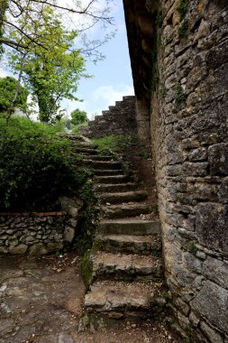 Titano Dağı 'ndaki Guaita Kalesi' ndeki eski taş merdivenler, ağaç ve mavi gökyüzü ile San Marino 'nun en ünlü kulesi. 