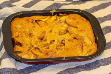 Çizgili masa örtüsünün üzerindeki pasta kutusundaki elma Charlotte.. 