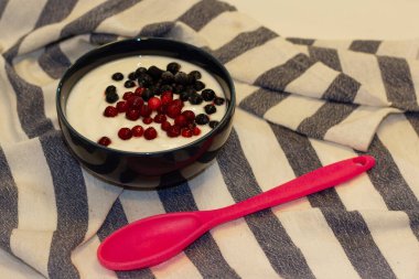 Yaban mersinli yoğurt ve plastik kaşıklı yaban mersini..