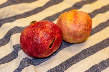 Çizgili bir masa örtüsünde iki nar..
