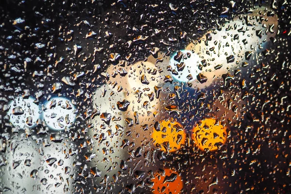 Día lluvioso, gotas de lluvia en la ventana, tiempo lluvioso, lluvia y semáforos bokeh, atasco de tráfico, desenfocado — Foto de Stock