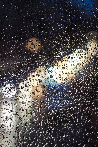 Día lluvioso, gotas de lluvia en la ventana, lluvia y semáforos bokeh, atasco de tráfico. Desenfocado — Foto de Stock