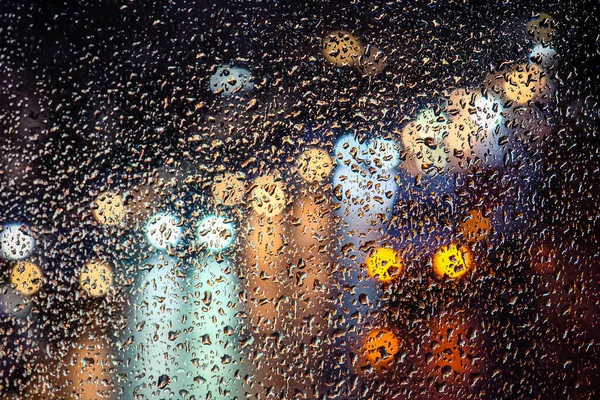 Día lluvioso, gotas de lluvia en la ventana, lluvia y semáforos bokeh, atasco de tráfico. Desenfocado — Foto de Stock