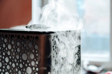 Sabah ışığında nemlendiriciden çıkan buhar. Hava nemlendiricisinden çıkan buhar. Bir evde hava nem seviyesi. Seçici odak