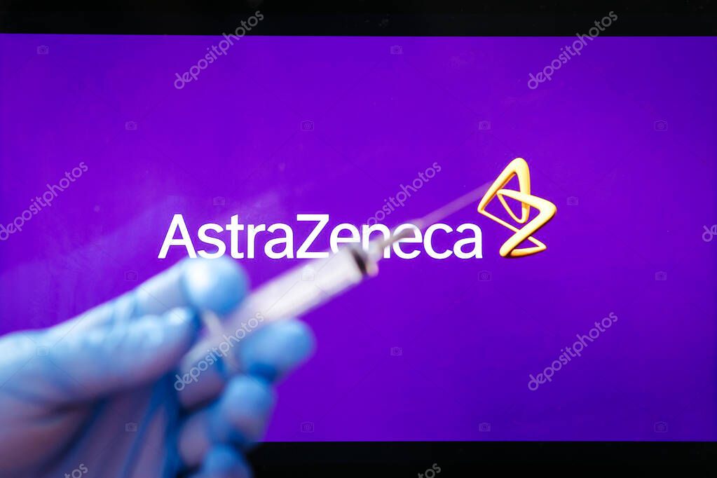 AstraZeneca Covid-19 vaccine concept. Close-up of a syringe and and, the AstraZeneca company logo in the background. Defocused. High quality photo