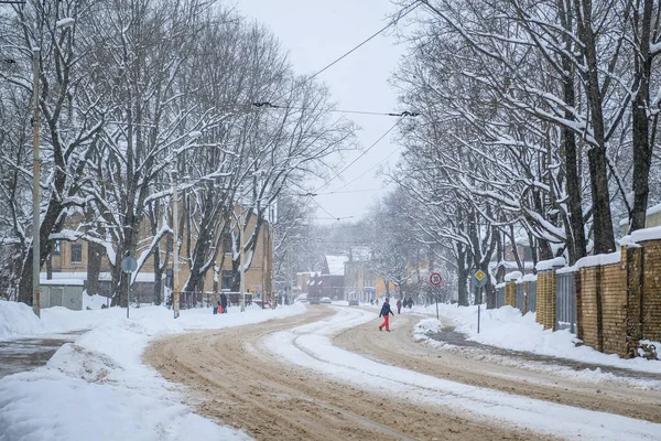 Tempesta di neve e strada innevata e auto con un pedone solitario — Foto Stock