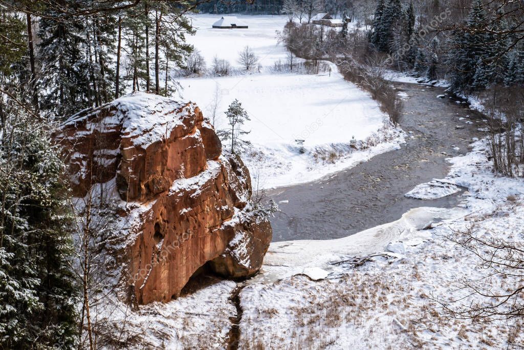 Zvartas red rock and river Amata at city Cesis in Latvia. Winter photo