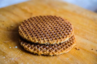 Geleneksel Hollandalı Stroopwafels, bal gofretleri, tahta bir tahtanın üzerinde. Seçici odak